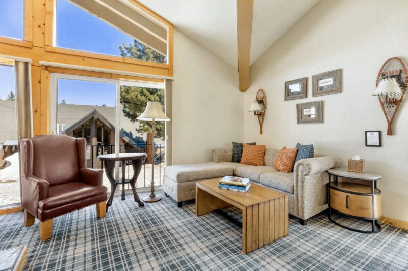 Neat living room setup with a sofa set by the glass window, and portraits above.