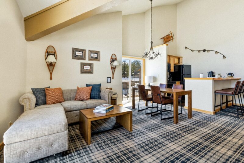 Neat living area, sofa set in left corner, and kitchen space on the right.