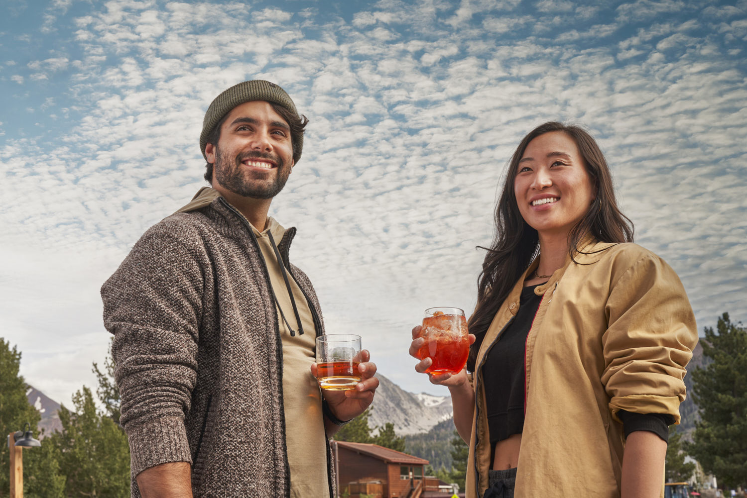 A man and a lady savoring drinks beneath a beautiful sky, relishing the moment.