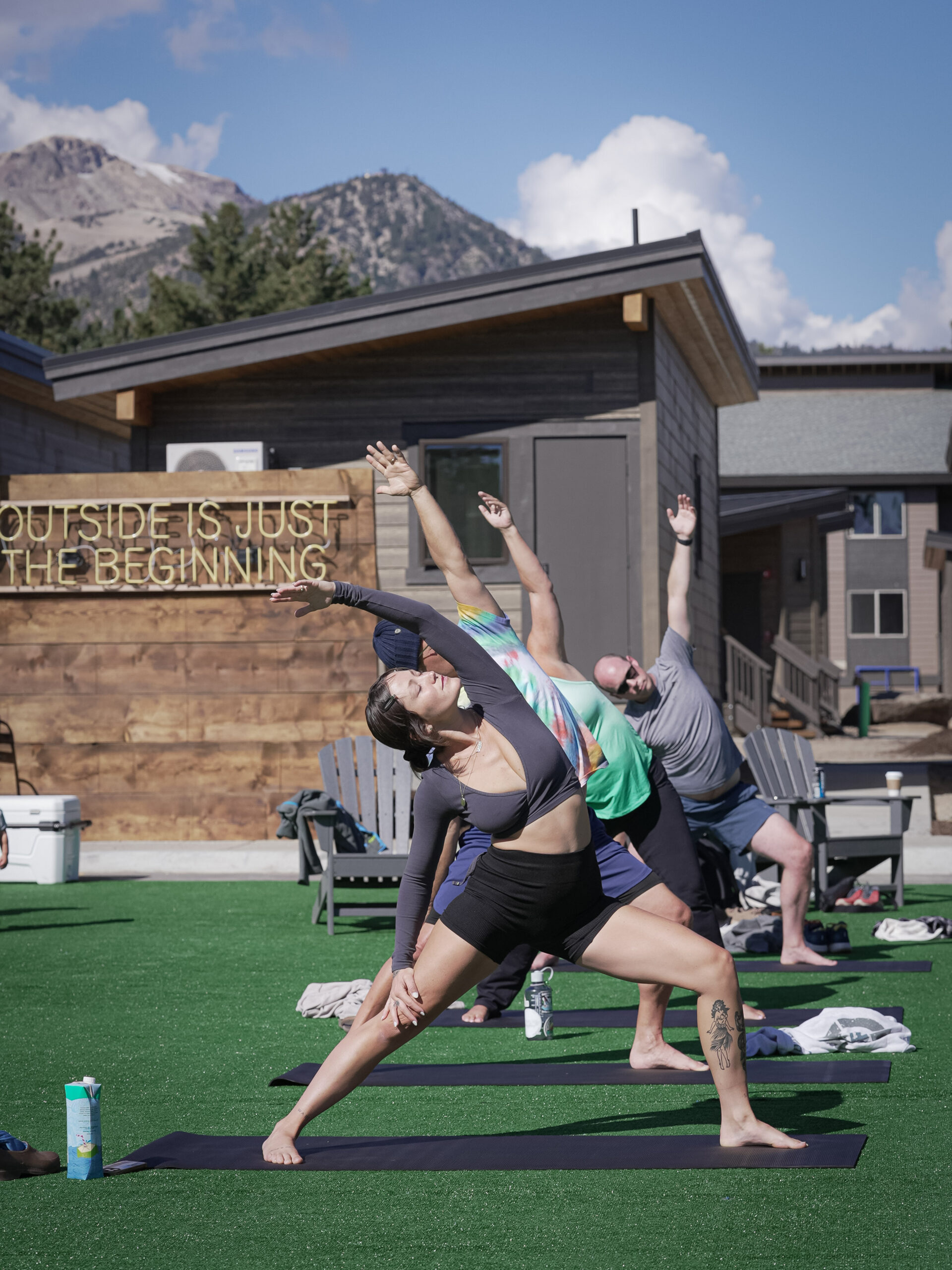 People practice yoga on mats in an open field, embracing a tranquil outdoor experience.
