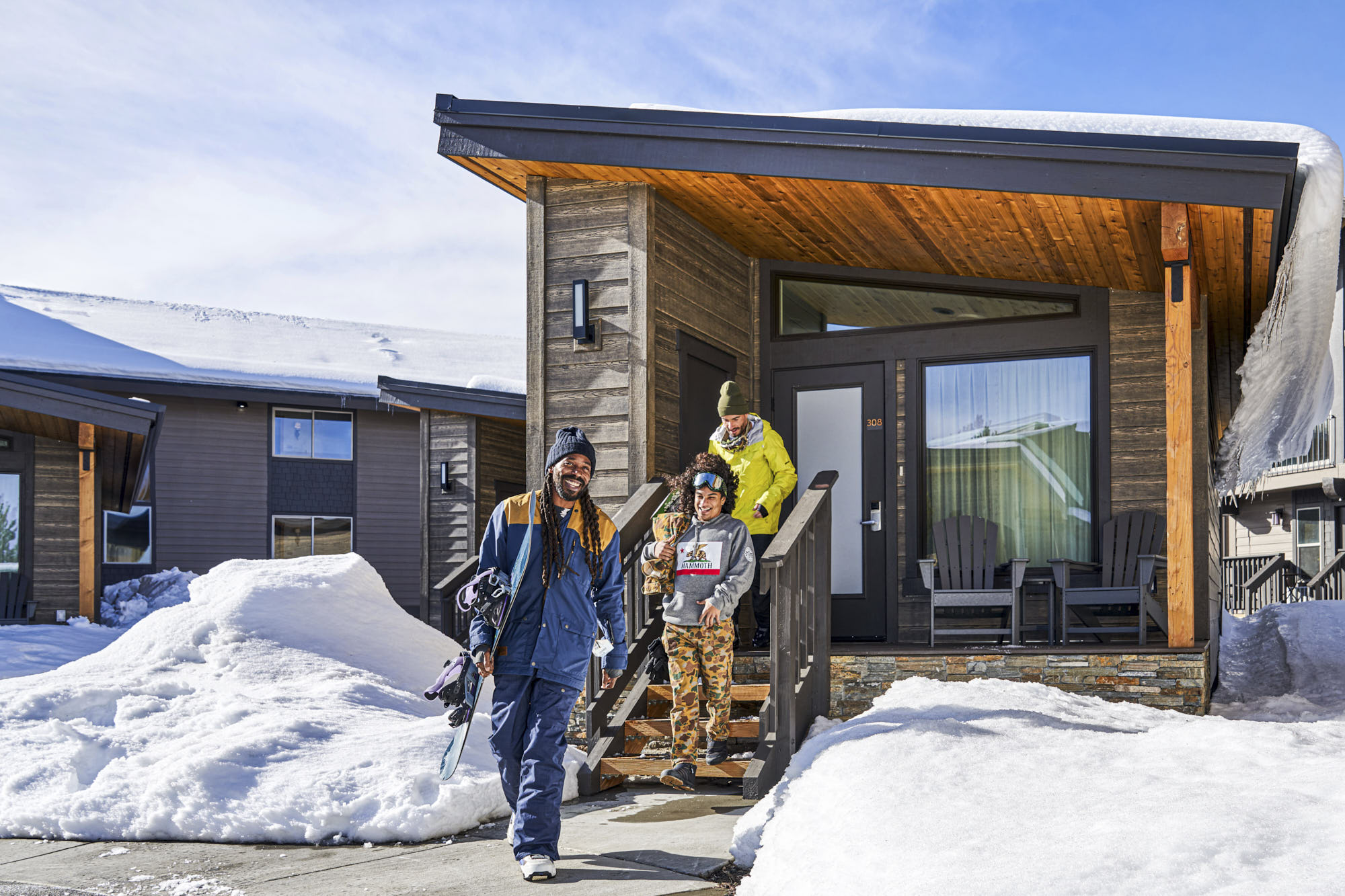 Snowboarders leaving cozy cabin, getting ready for a day on the slopes