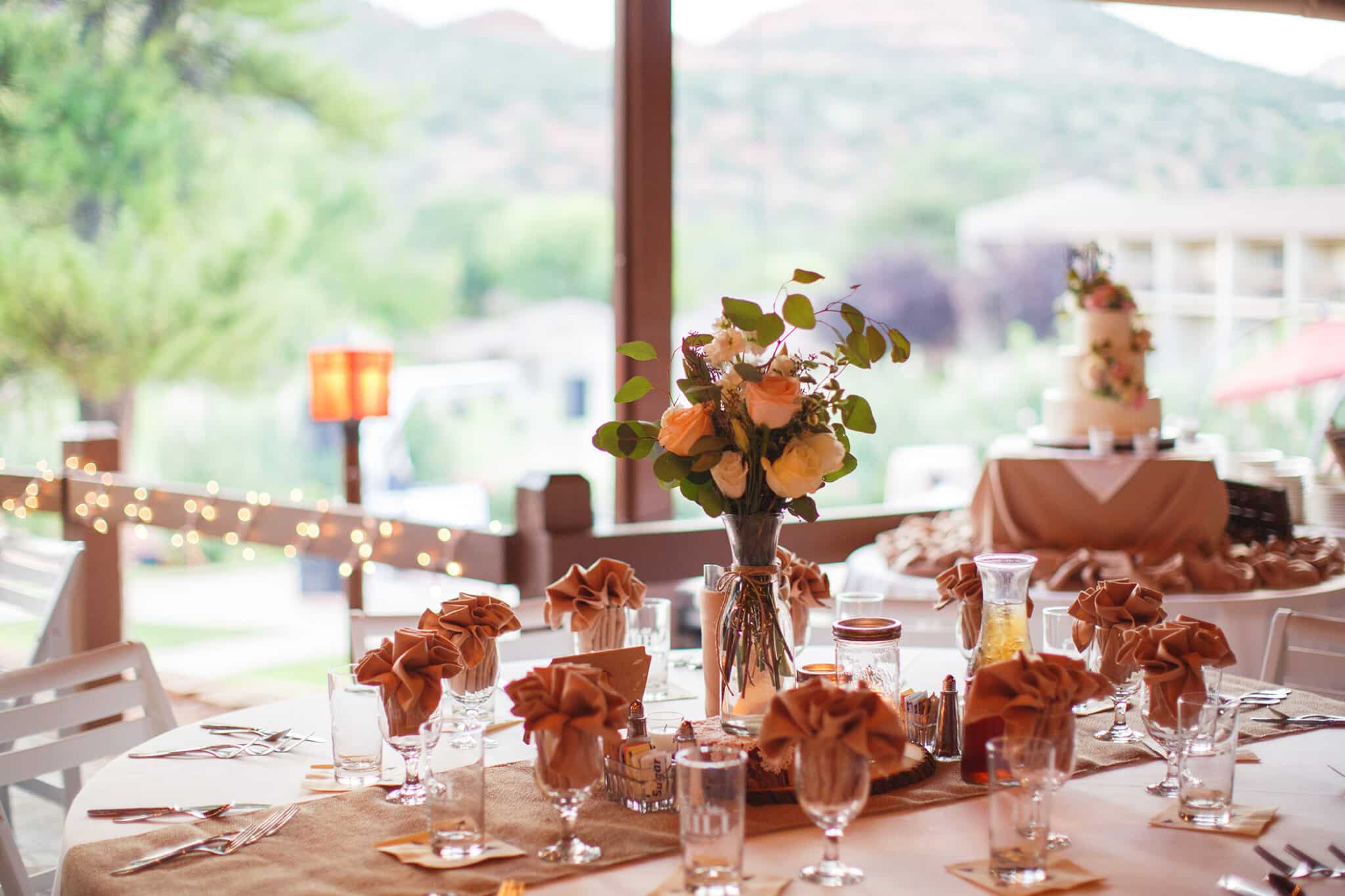 A beautifully set dining table with flowers, glasses, and utensils.