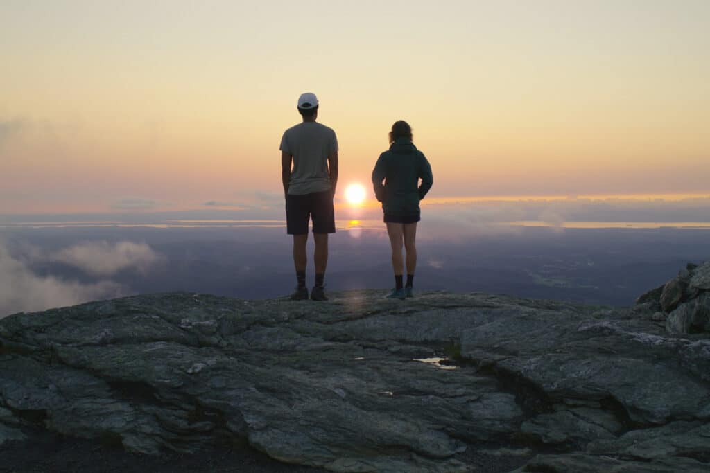 two hikers on a mountain overlook in Stowe Vermont