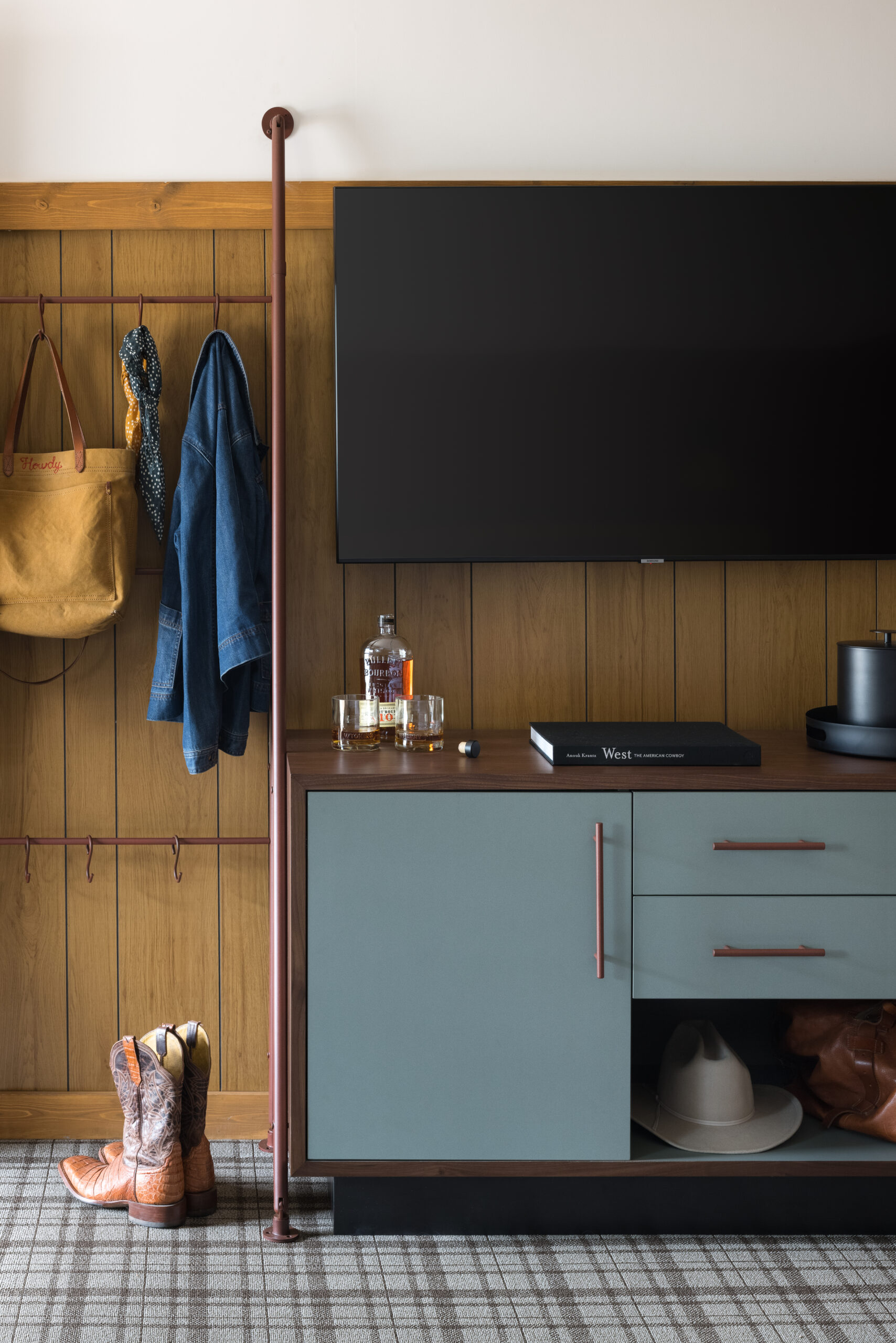 Wall-mounted TV, well-organized cabinet, and neatly hung clothes and handbags create an orderly arrangement.