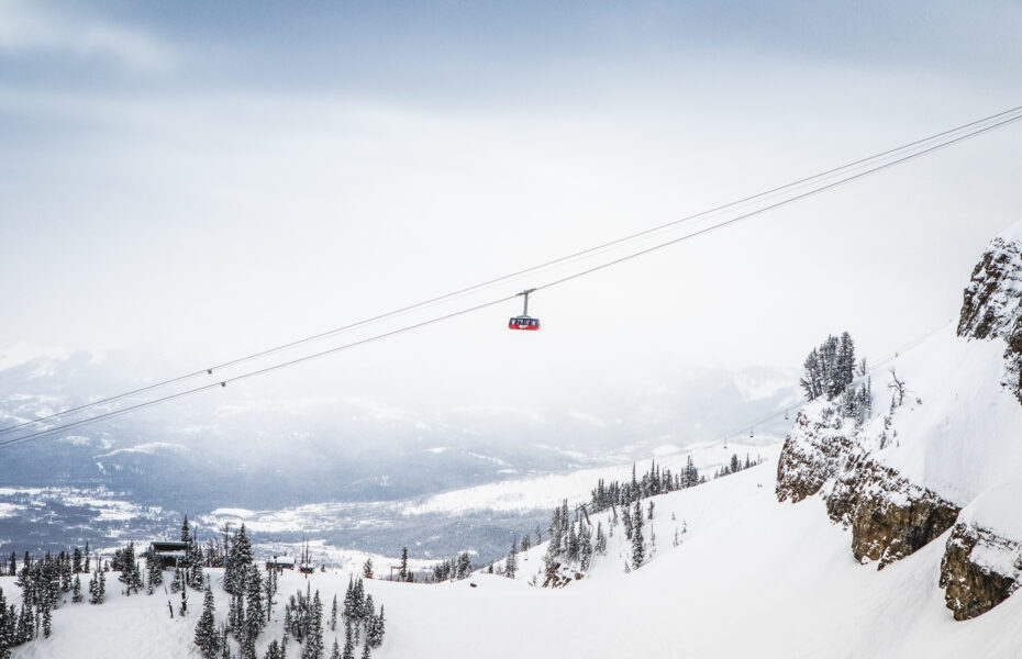 Cable car glides above snowy mountains, offering a breathtaking and wondrous scenic panorama.