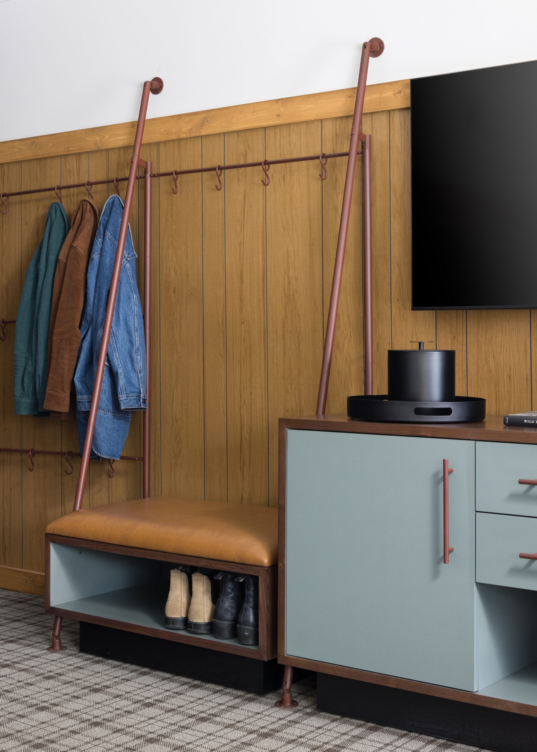 Clothes are properly hung, and shoes are neatly arranged on the rack beside the TV cabinets, with a TV mounted above.
