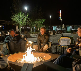 Seated people enjoy winter conversations by the bonfire during the nighttime ambiance.