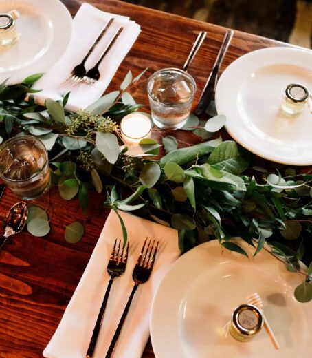 Table displays well-arranged crockery with a decorative green leaf for an added touch.