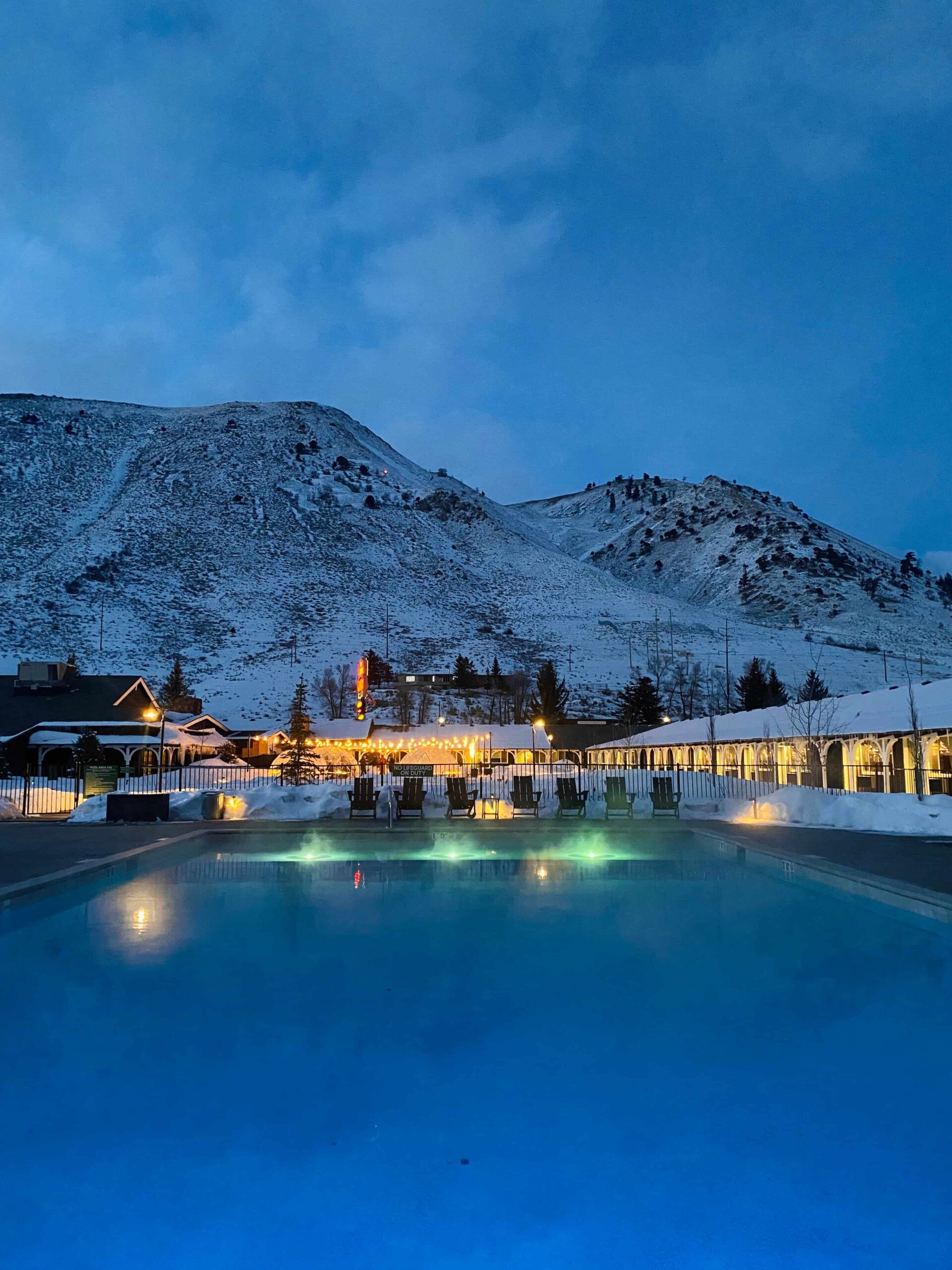 The snowy mountain backdrop enhances the awesome pool area night view with dazzling lightning.
