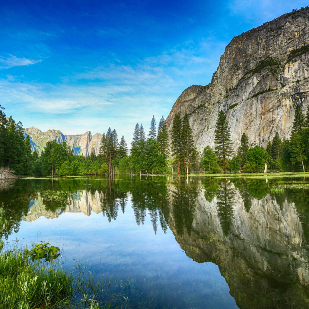 Breathtaking mountain scenery showcases nature's splendor with water, lush greenery, and abundant trees.