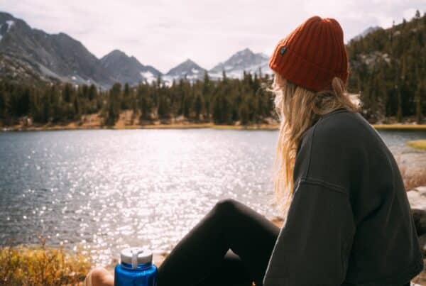female sitting my the lake