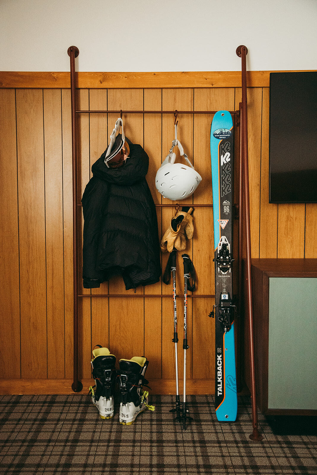Organized display of winter gear, including snow diving clothes, snowboard, and snowshoes neatly hung.